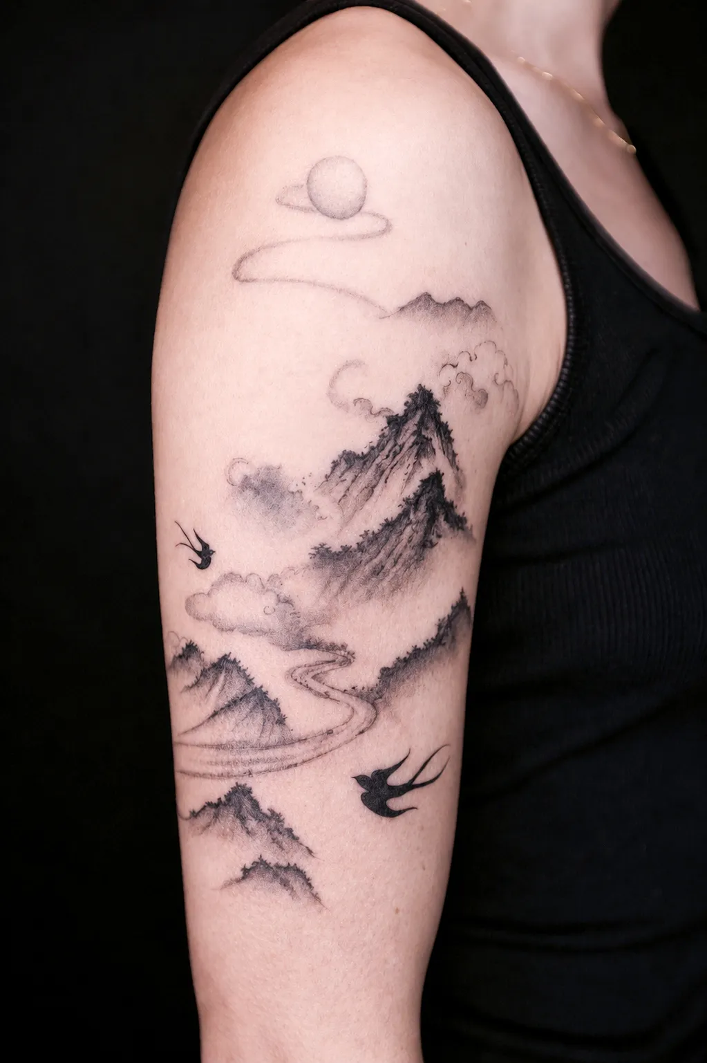 Finished upper-arm tattoo of misty mountains a winding river and two flying swallows