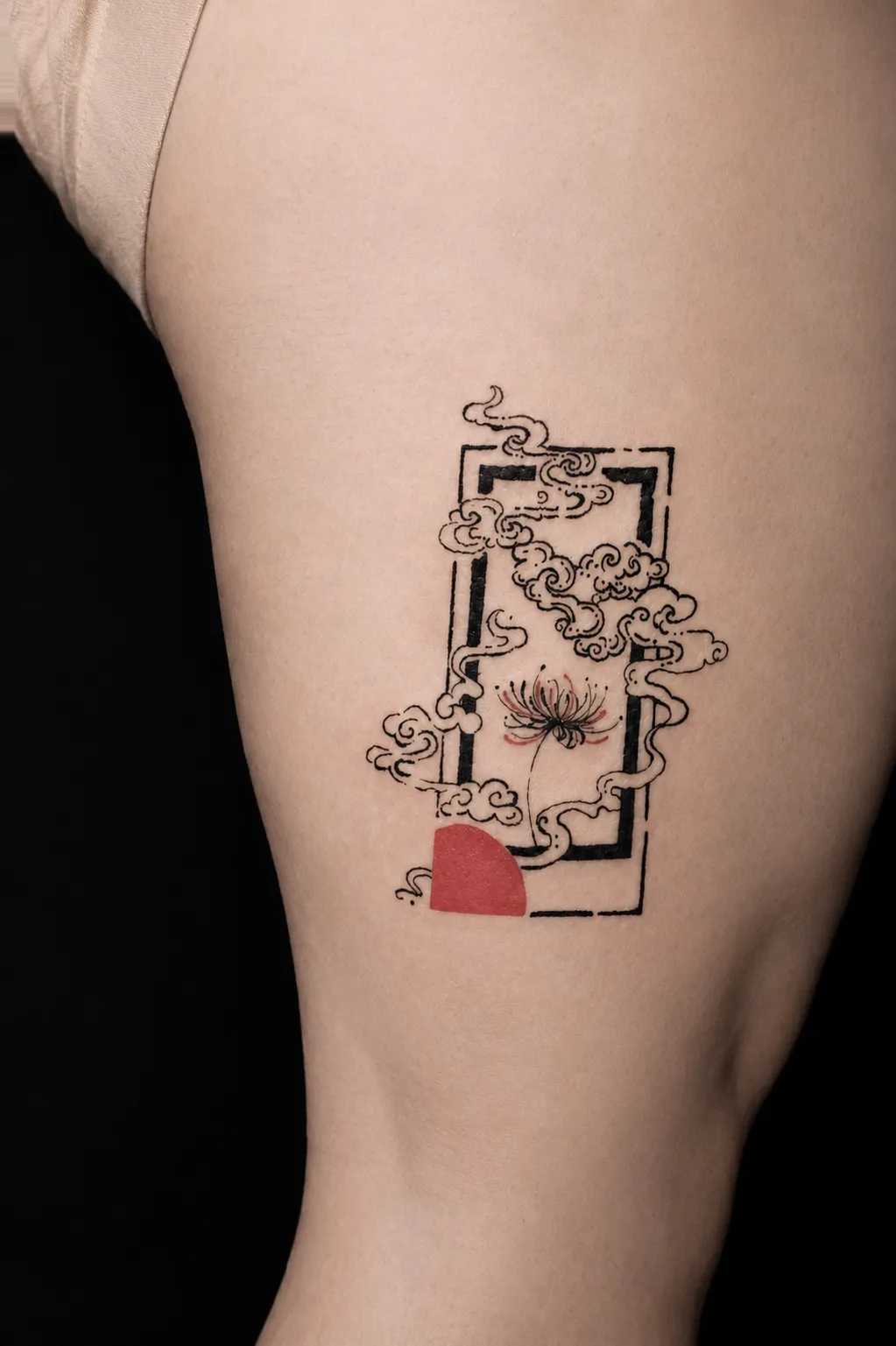 Finished thigh tattoo of a fine red spider lily surrounded by black clouds and an open frame